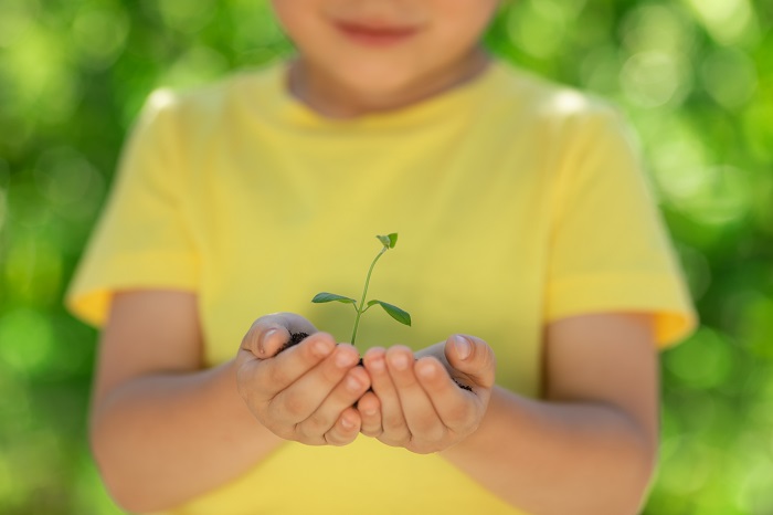 an eco-friendly child holding a plant